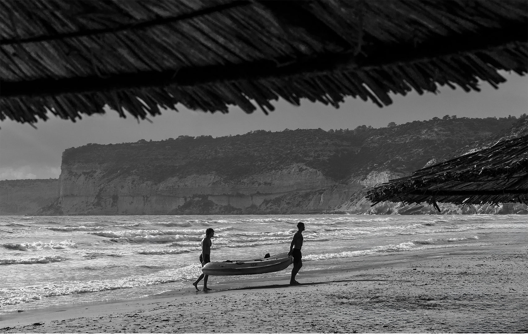 papadopavlos street photography. 2 men carrying a boat